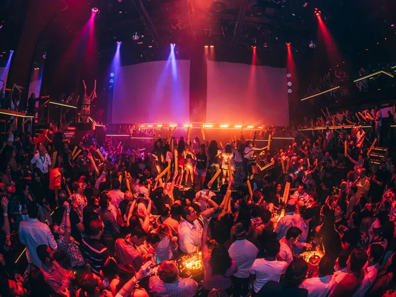 A packed dance floor under red and blue stage lights at Coco Bongo Cancún