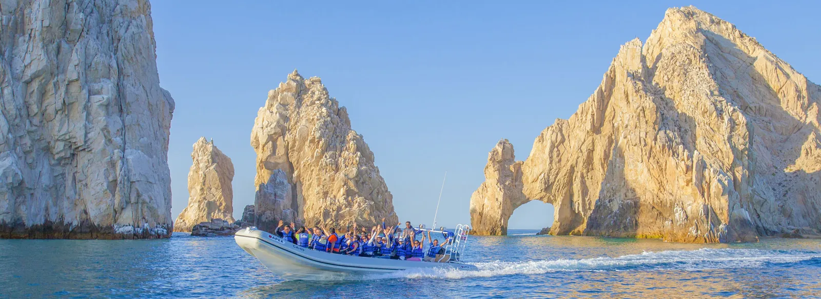 Tour boat full of guests passing the rock arch at Land’s End in Cabo San Lucas