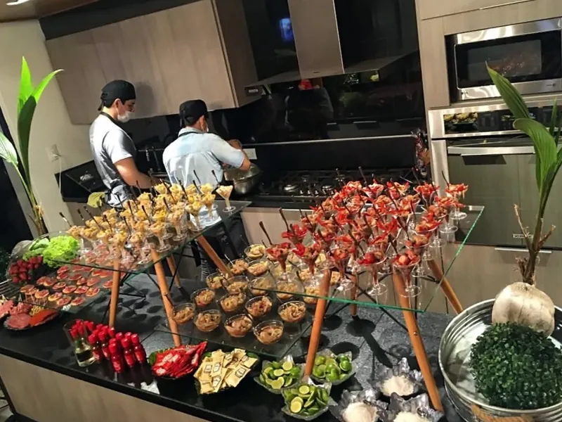 Two chefs at work behind a spread of canapés in a villa kitchen