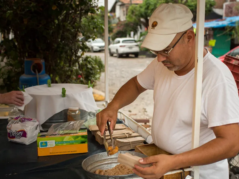 Cook preparing tacos at a street stall