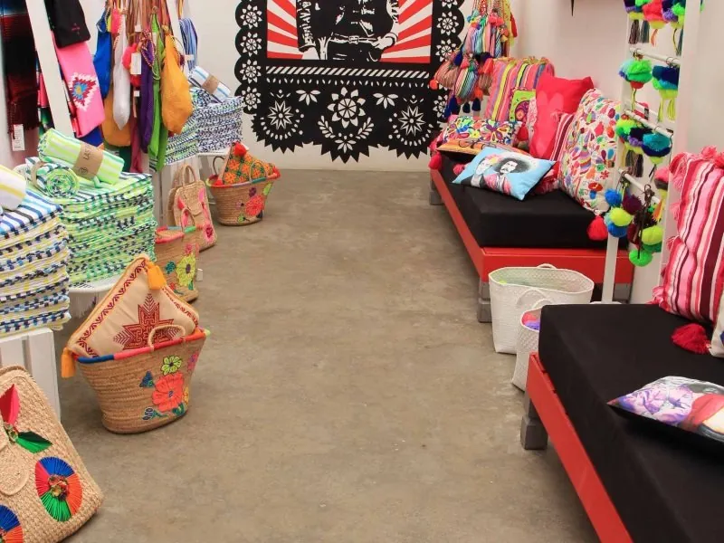 Boutique in Sayulita with embroidered cushions, woven baskets and papel picado on the wall