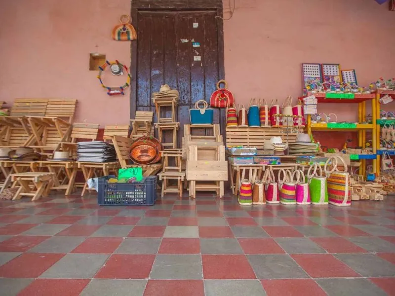 Shop front with handmade wooden furniture, baskets and toys on a pink wall