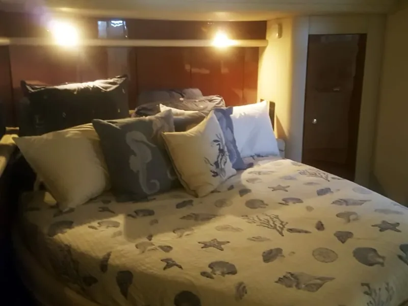 Double cabin with sea-themed bedding and pillows below deck
