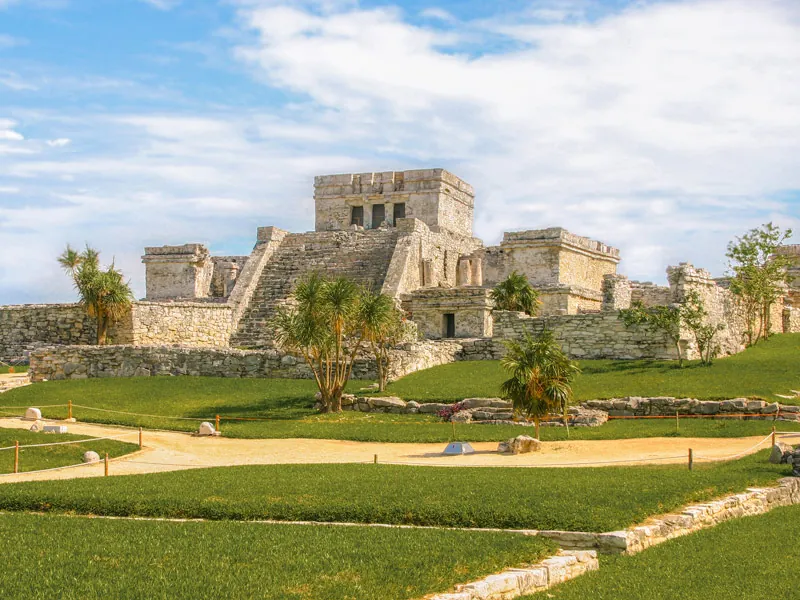 El Castillo, the main temple at Tulum, behind green lawns and palms