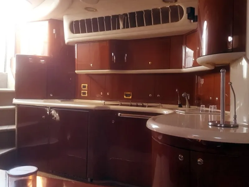 Galley with glossy wood cabinets and cream counters