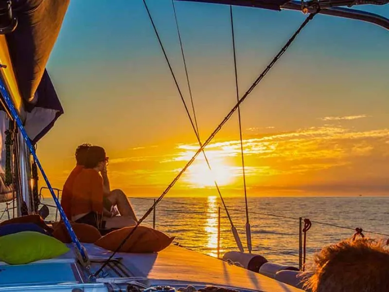Guest watching the sunset from the deck of a sailboat