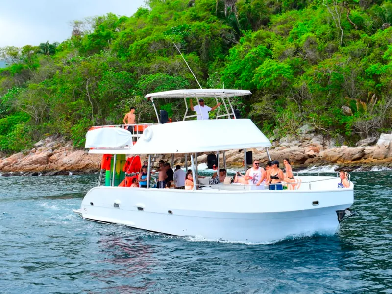 Guests aboard a double-deck boat near a green headland