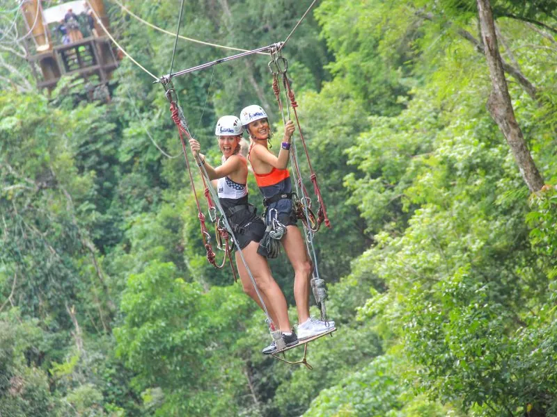 Guests crossing a suspension bridge in the jungle canopy