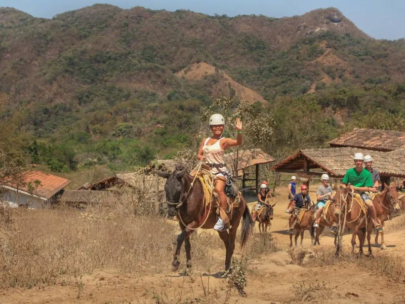 Guests on a mule ride through a mountain village