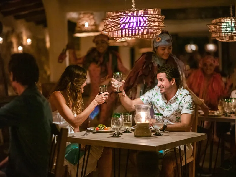 Guests toasting at a candlelit dinner table