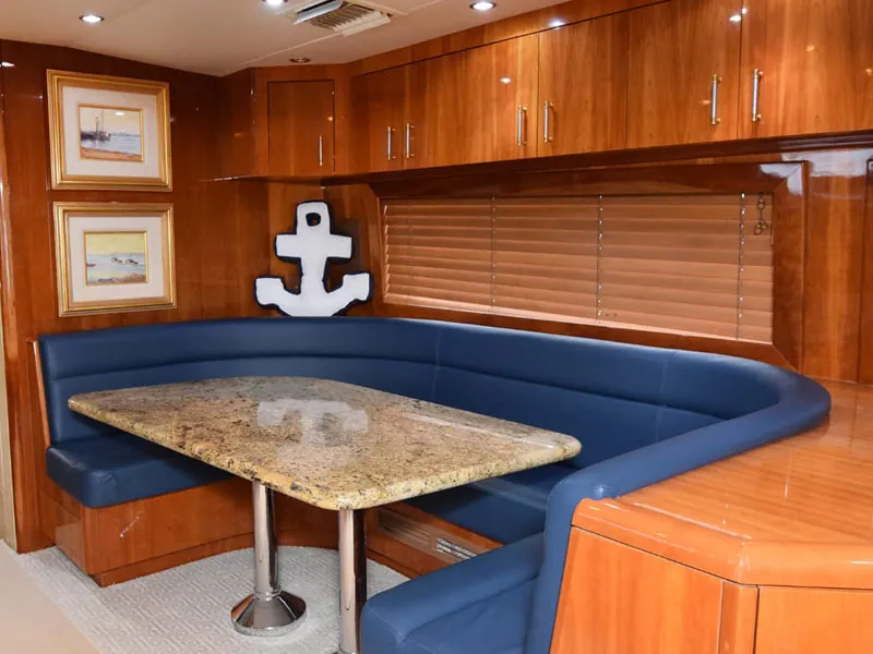 Blue leather dinette in the wood-paneled salon of the Hatteras 70