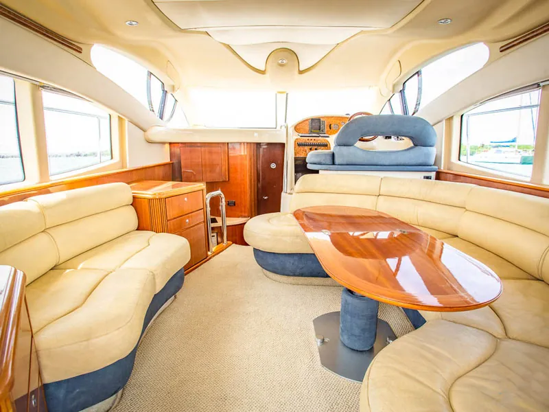 The cream leather salon of the Azimut 42 with a polished wood table and wide windows