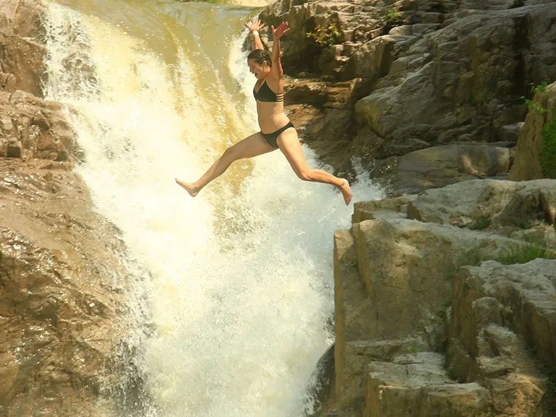 Guest leaping from the rocks into the pool of the El Salto waterfall