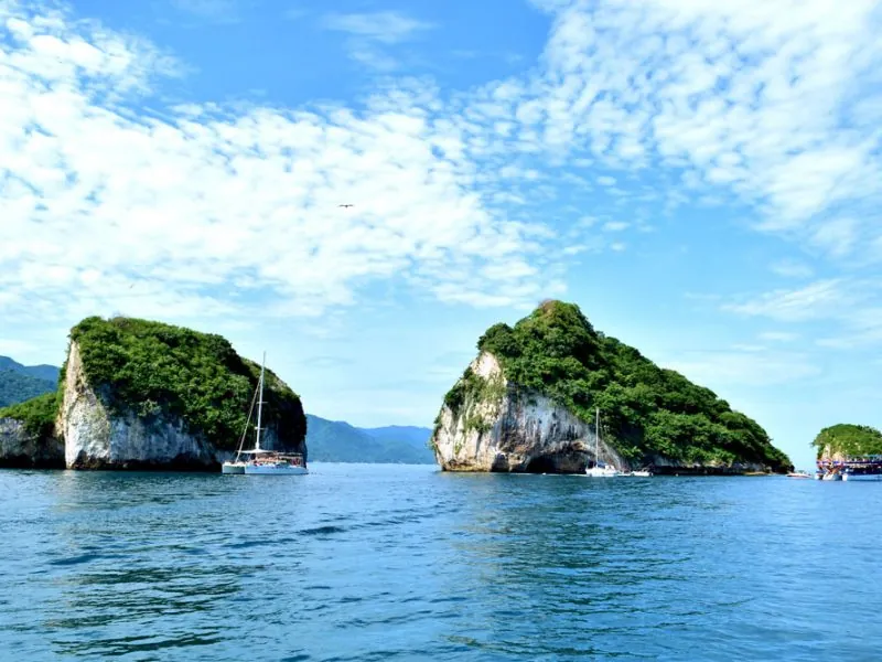 The granite islets of Los Arcos with a sailboat anchored between them, Puerto Vallarta