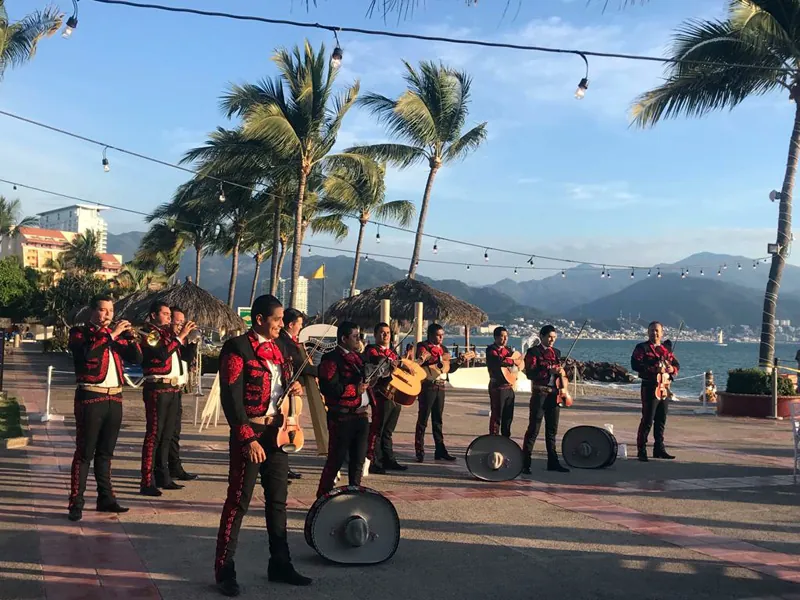 Mariachi band performing on the Puerto Vallarta boardwalk with the bay behind