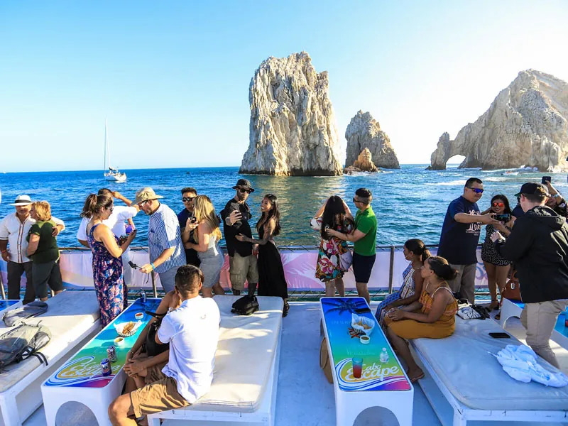 Guests on the open catamaran deck facing the granite pinnacles of Land’s End