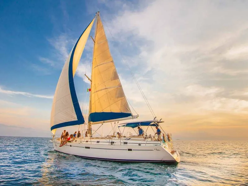 Sailboat under a golden sky with guests aboard