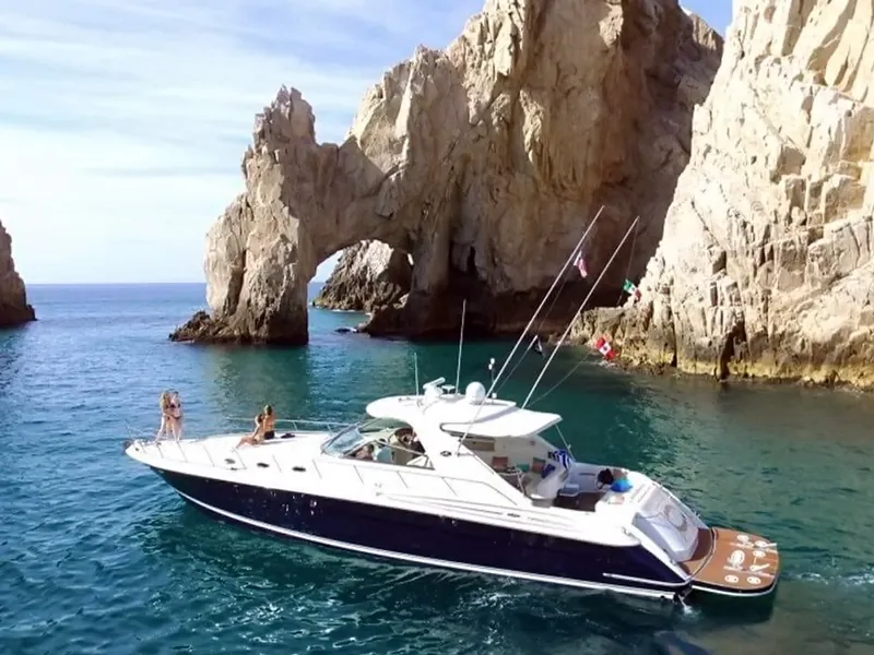 Sea Ray motor yacht with guests on the bow beside the Arch at Land’s End, Cabo San Lucas