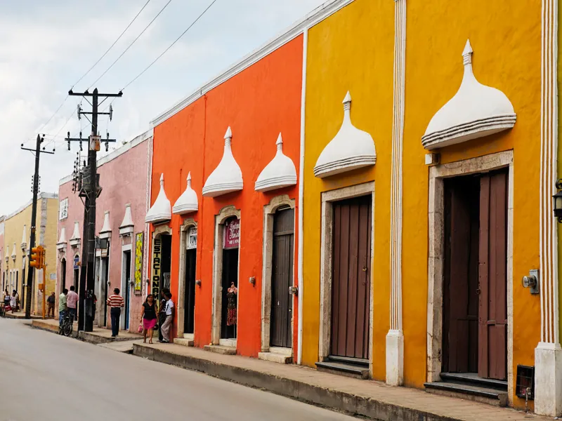 Colonial facades painted orange, yellow and pink along a street in Valladolid