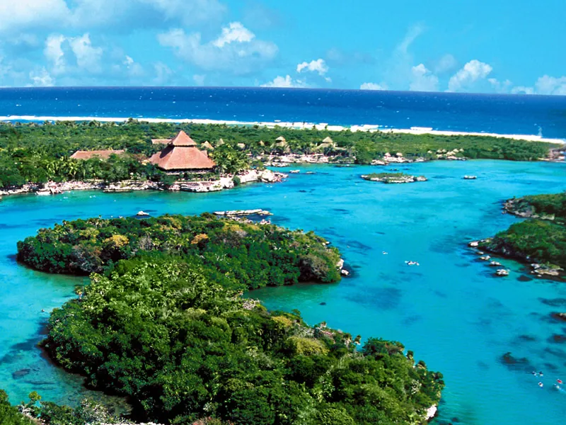 Aerial view of the turquoise inlet at Xel-Há, with jungle islands and the Caribbean behind