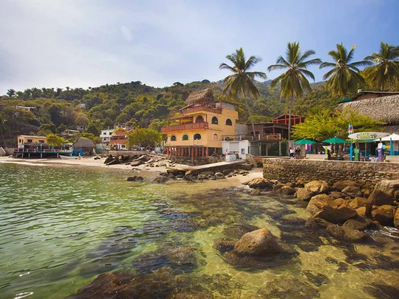 Houses and palapa restaurants along the rocky waterfront of Yelapa village