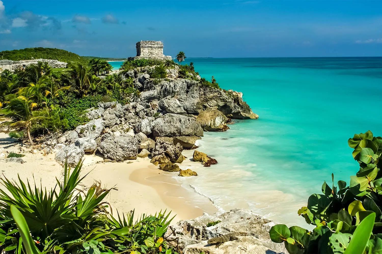 Mayan temple of Tulum on a limestone cliff above a white-sand beach and turquoise Caribbean water