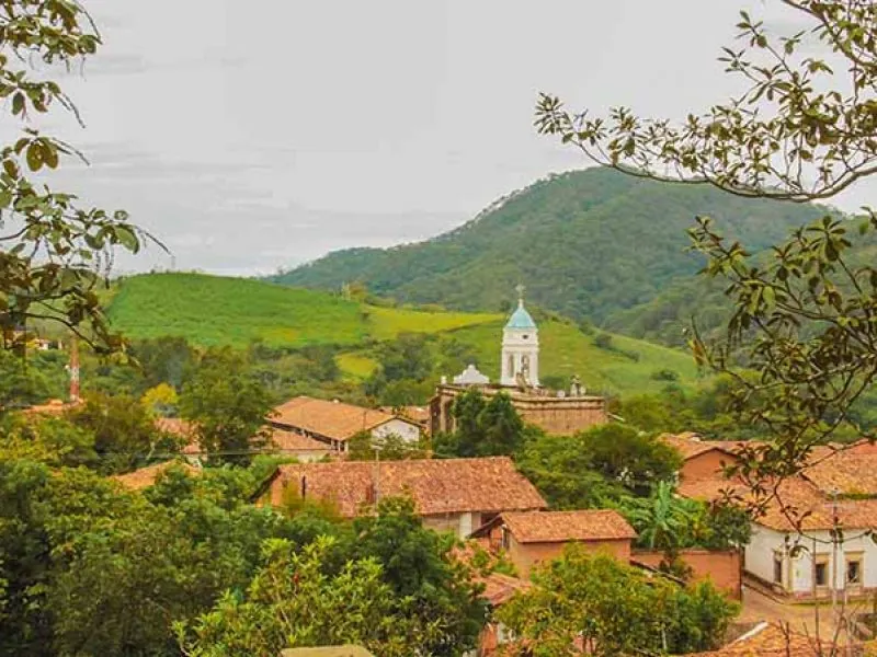 Village church tower among green mountain hills