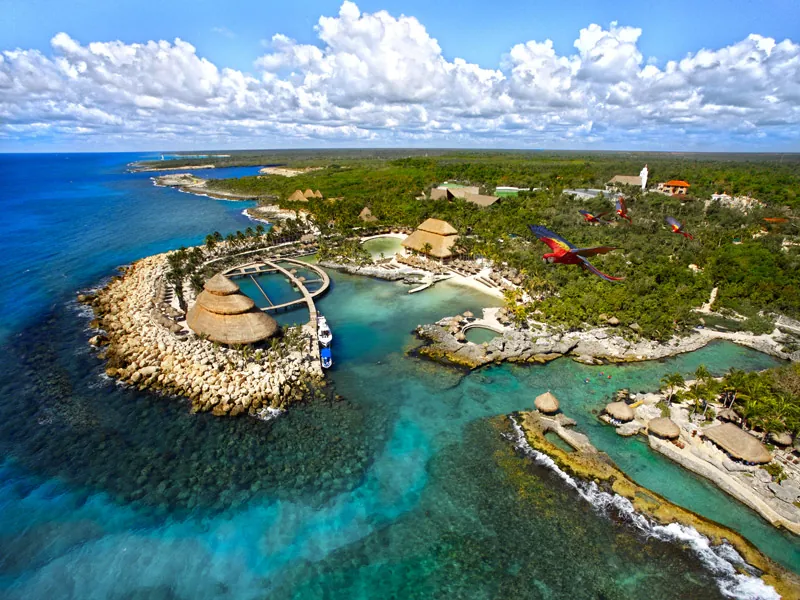 Aerial view of Xcaret park on the Riviera Maya: coves, lagoons, thatched roofs and jungle beside the sea